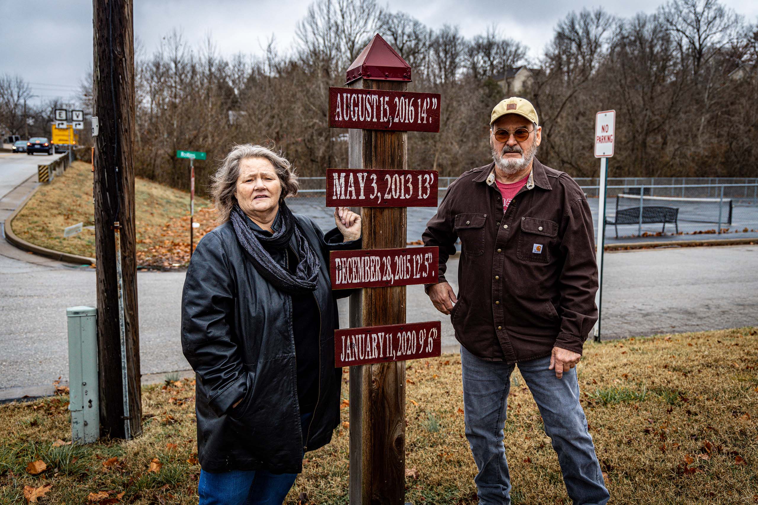 Susan Liley, left and Doug Smith, right, standing by flood marker.