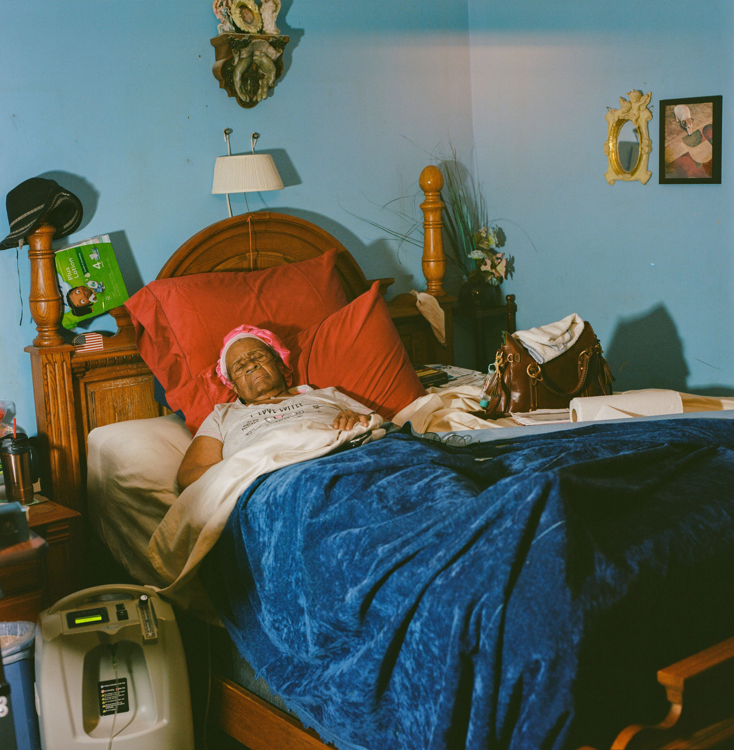 Mary Harris, 85, mother of Curtis Harris, lies in bed on a breathing machine, barely able to move, struggling with severe respiratory illness.