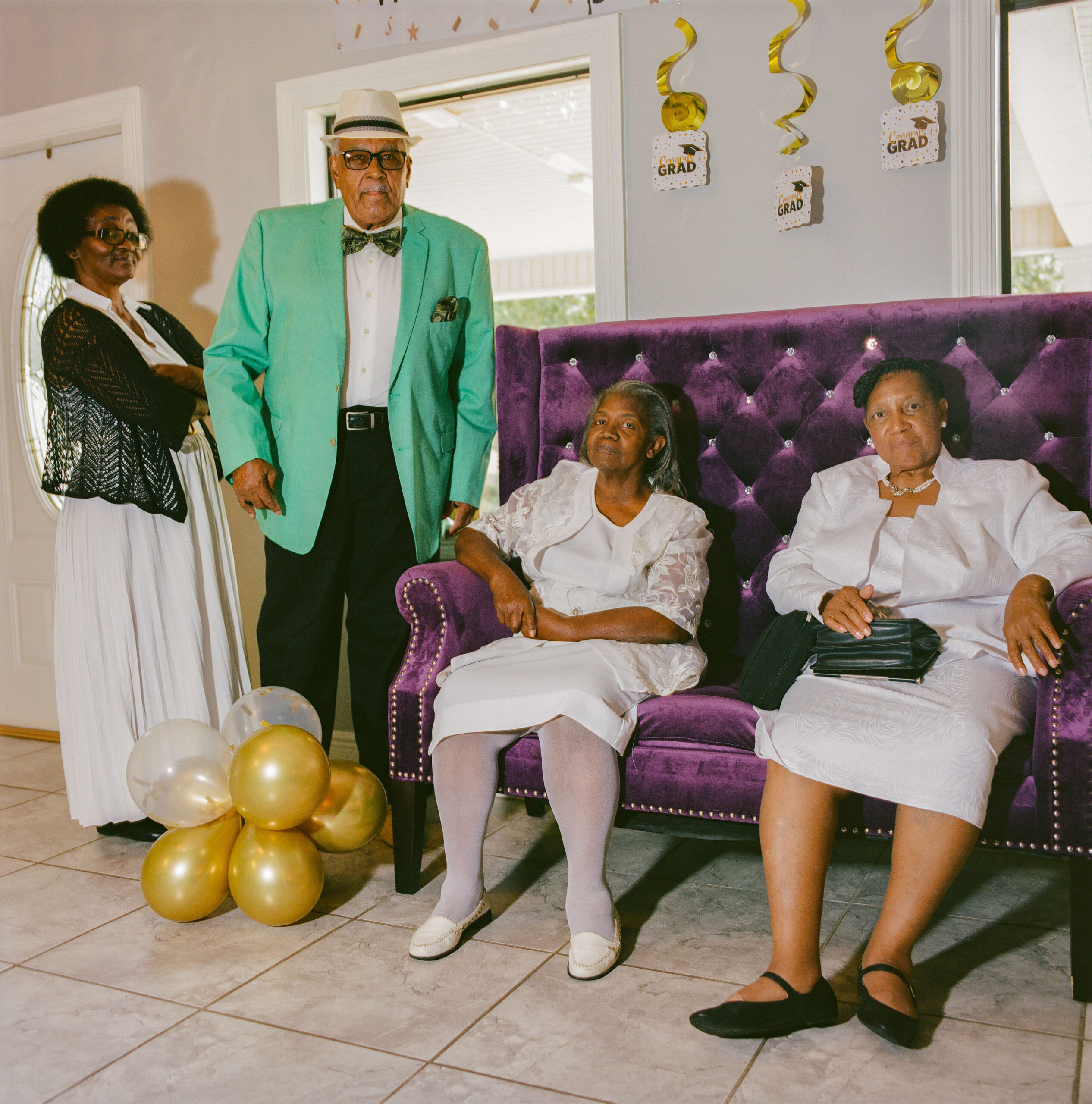 Local church visitors Elaine Catling (standing), Fannie Davis (left), and Dorothy Pickett (right) chat about life in Gloster while waiting at the church entrance.