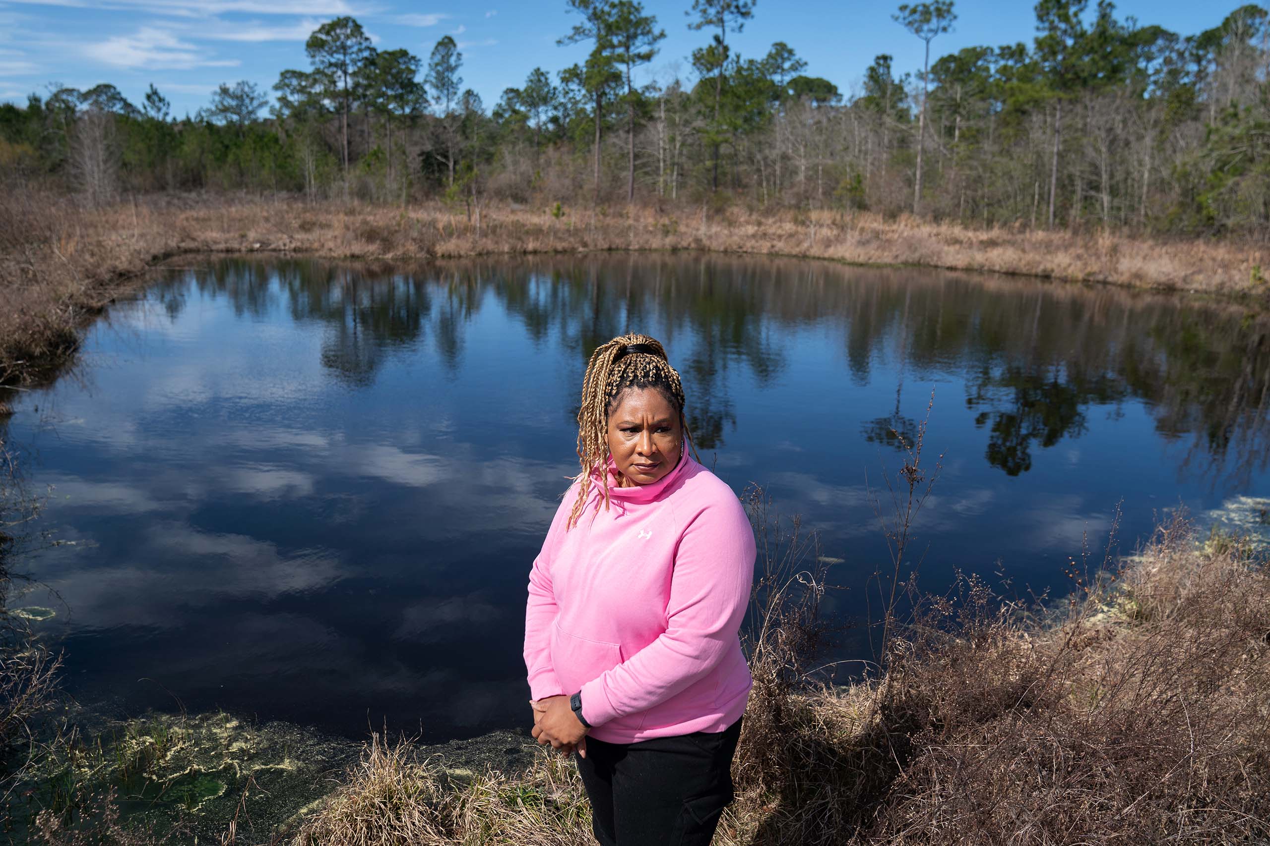 Carletta stands for a portrait by the pond at her property.