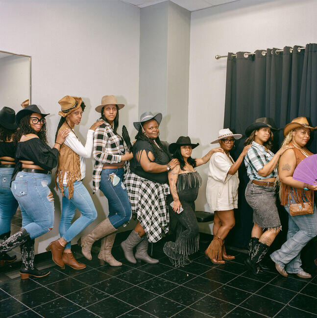 Women in cowboy hats at a Mother’s Day celebration at North Oak Plaza.