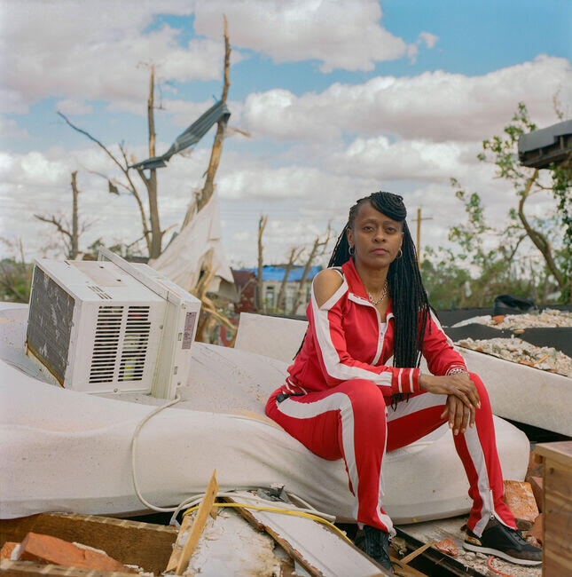 A local woman in the roof top of her new house that demolished during the tornado.