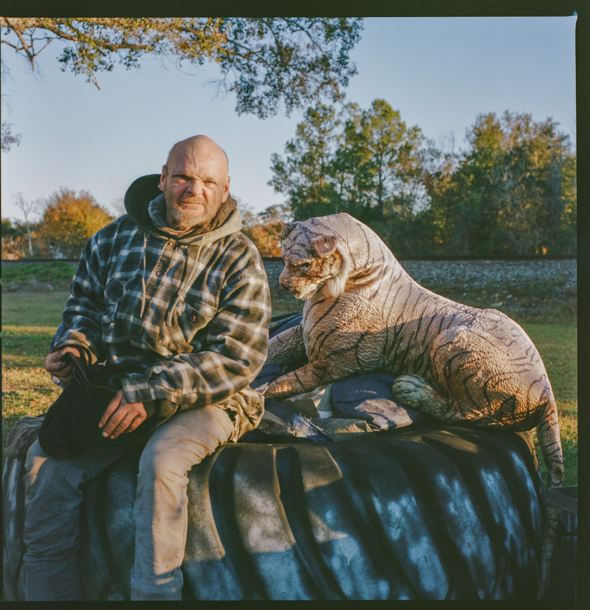 Unhoused man with a stuffed tiger toy.