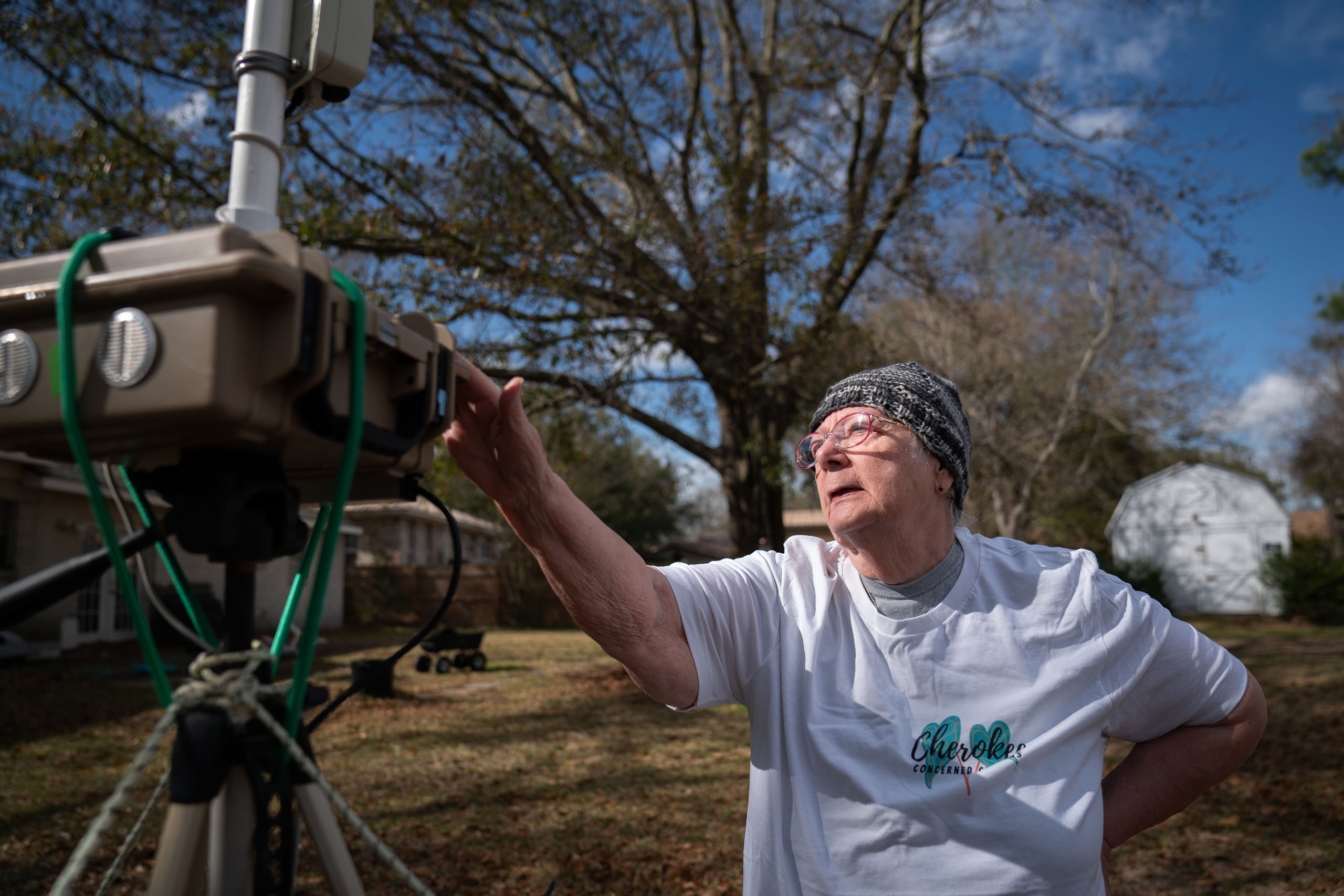 Barbara Weckesser, leader of Cherokee Concerned Citizens, examines a device that measures air quality outside her home.